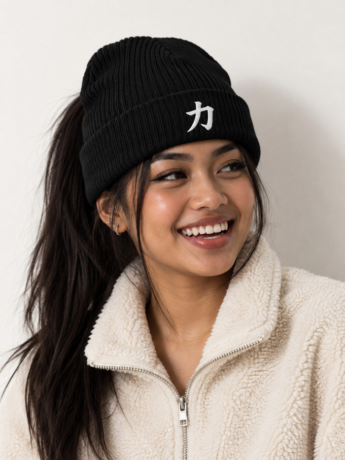 Laughing model with a high ponytail in a cream fleece wearing the black 5C5V Osaka Strength 力 organic beanie, three-quarter view