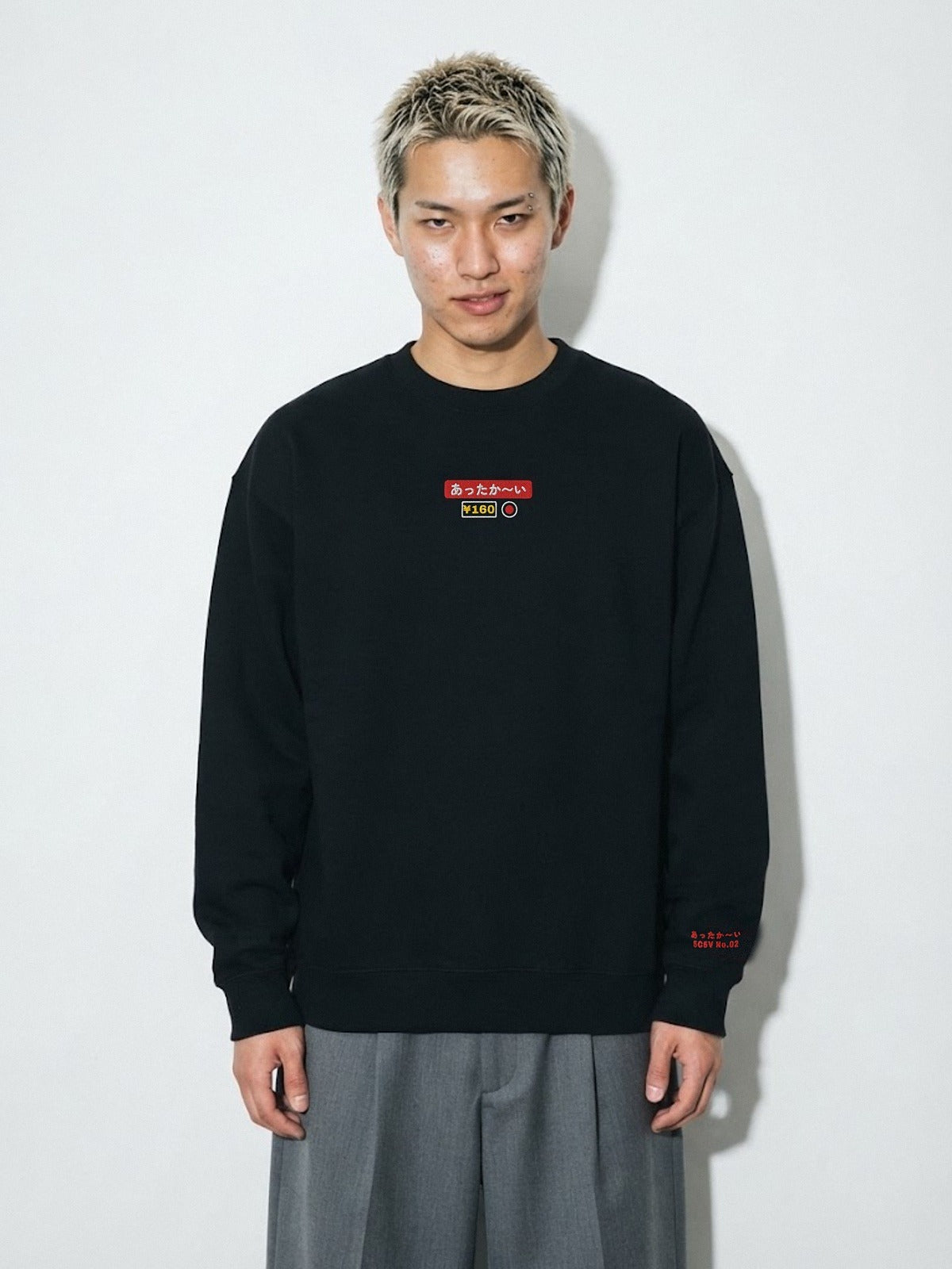 Model wearing the 5C5V Attaka-i あったか〜い heavyweight crewneck in Black, vending-machine button patch embroidered on the chest