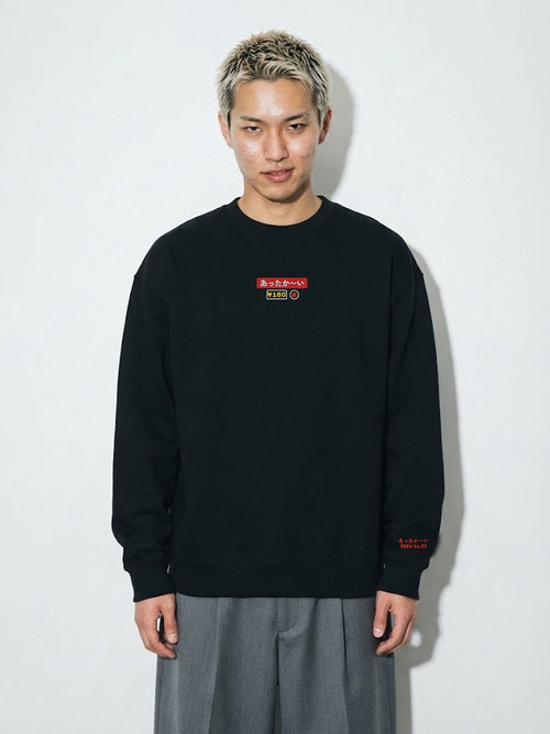 Model wearing the 5C5V Attaka-i あったか〜い heavyweight crewneck in Black, vending-machine button patch embroidered on the chest