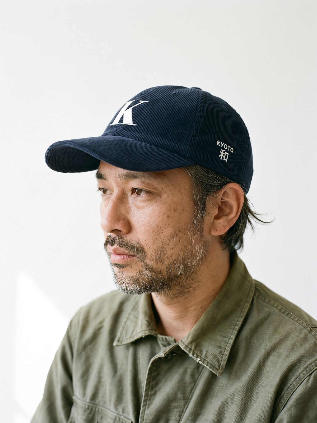 Side view of the 5C5V Kyoto K Corduroy Japanese baseball cap in navy, KYOTO above 和 (harmony) embroidered on the left side