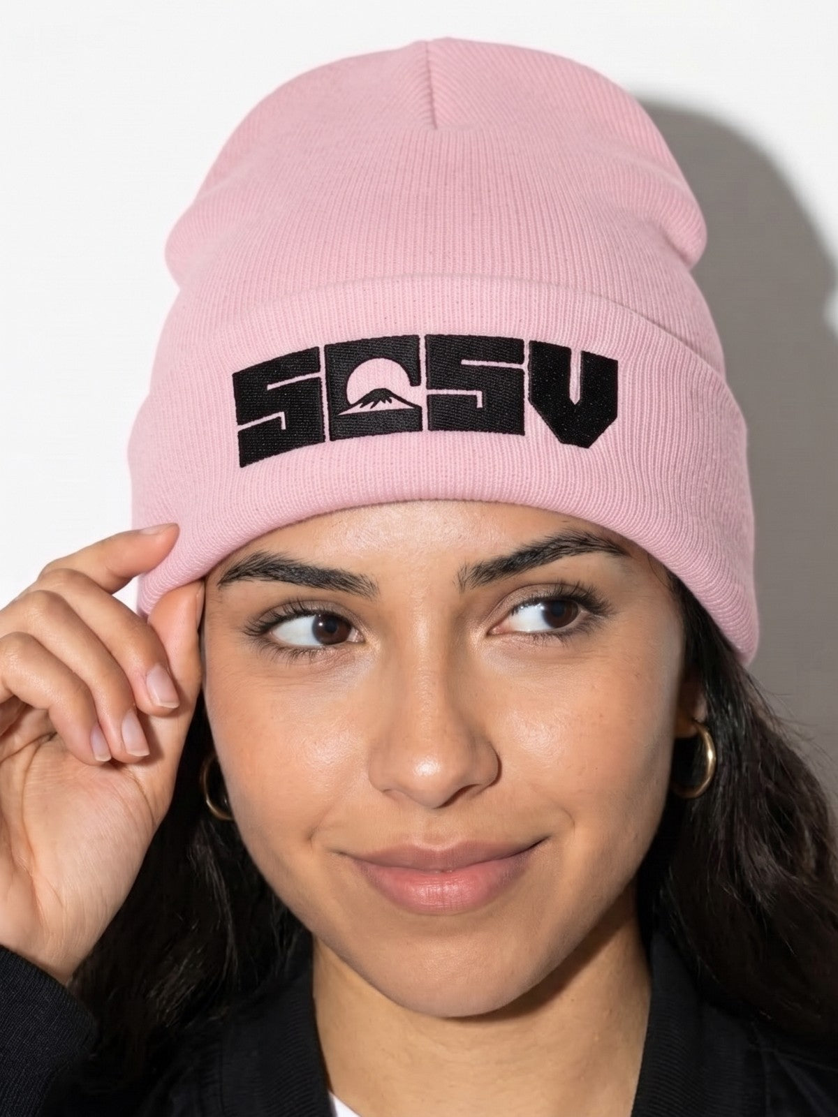 Model wearing the 5C5V Originals cuffed beanie in baby pink with the black embroidered 5C5V Mt Fuji logo, touching the cuff