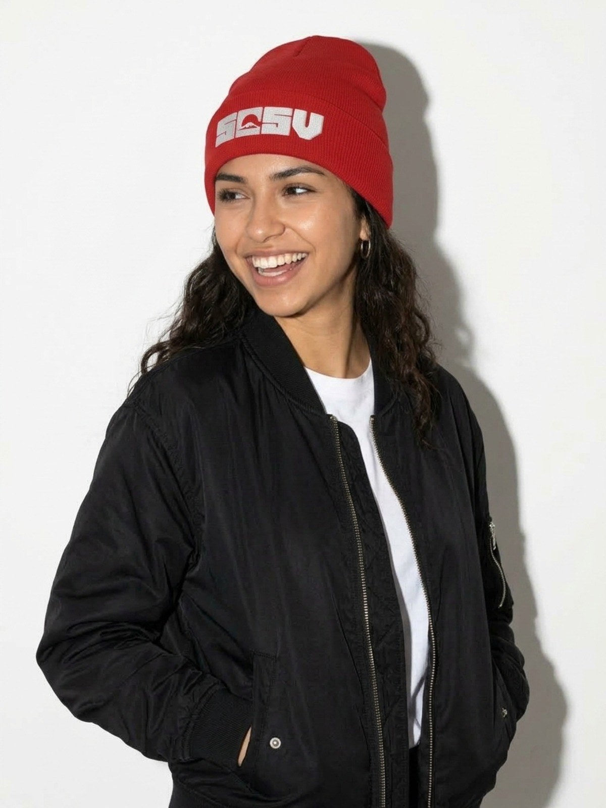 Laughing model in a black bomber jacket wearing the red 5C5V Originals cuffed beanie with white embroidered Mt Fuji logo
