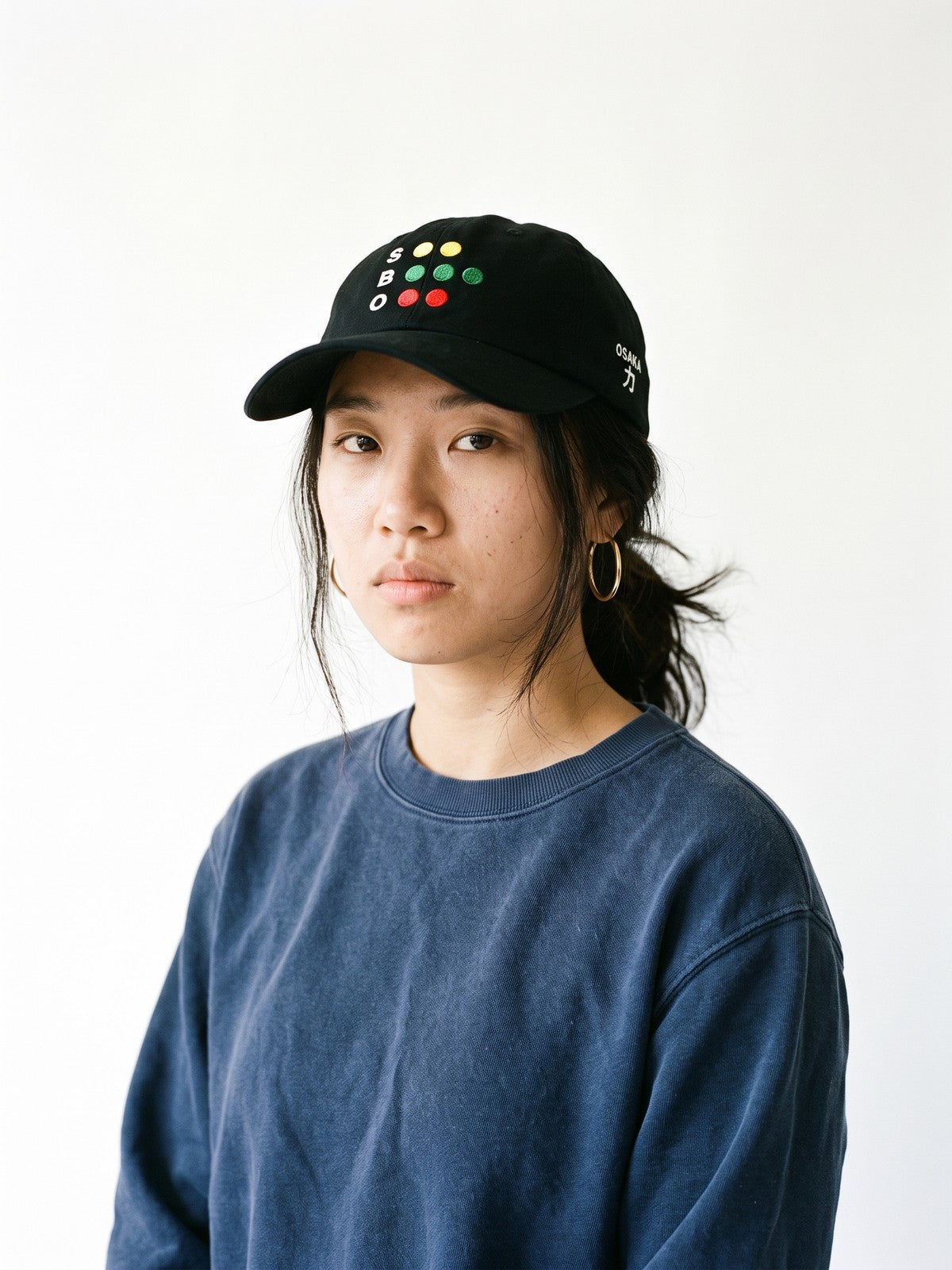 Model wearing the 5C5V Osaka Full Count Japanese baseball cap in black, the old S-B-O count board embroidered on the front, OSAKA and 力 (strength) on the left side