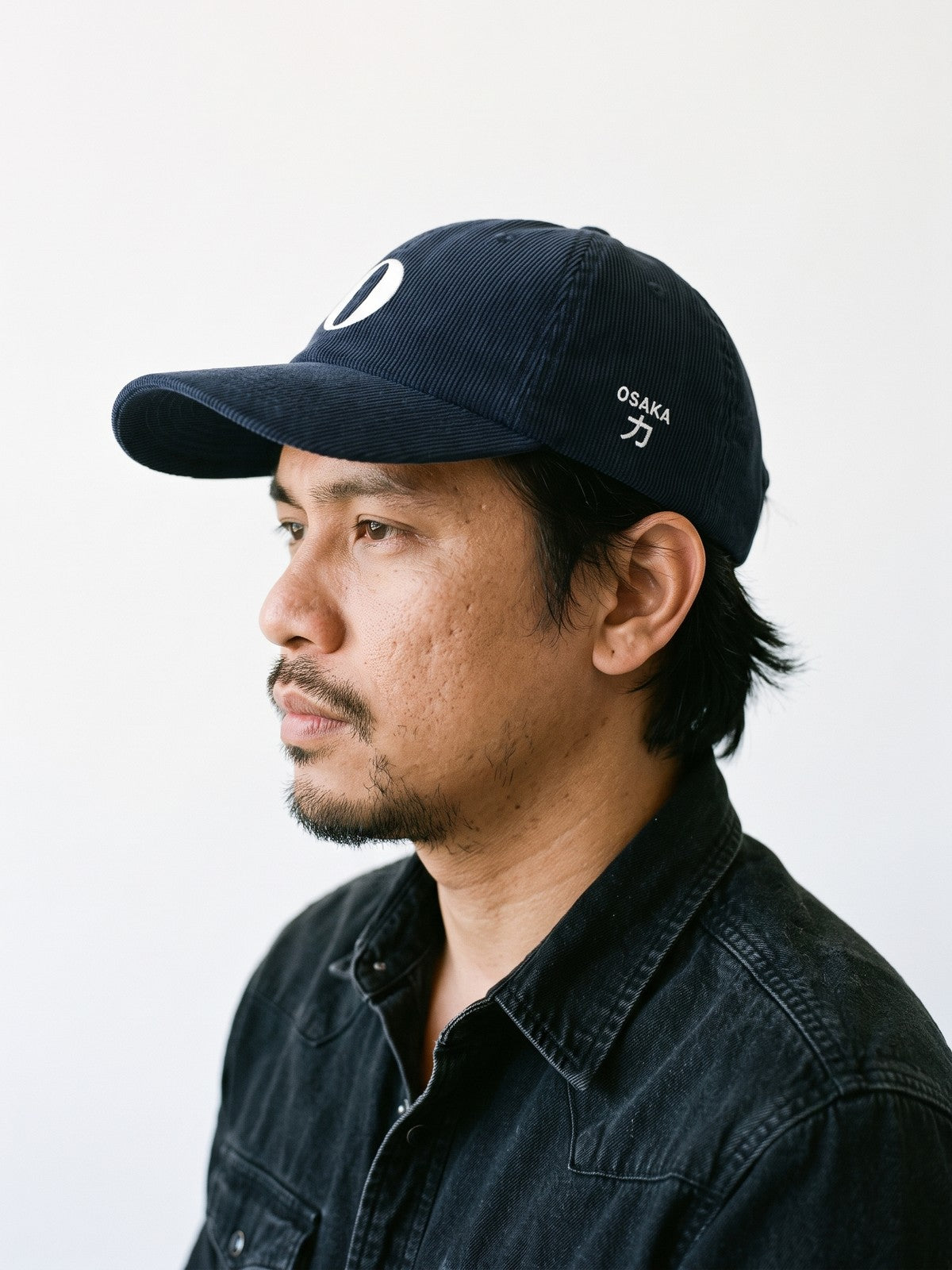 Side view of the 5C5V Osaka O Corduroy Japanese baseball cap in navy, OSAKA above 力 (strength) embroidered on the left side