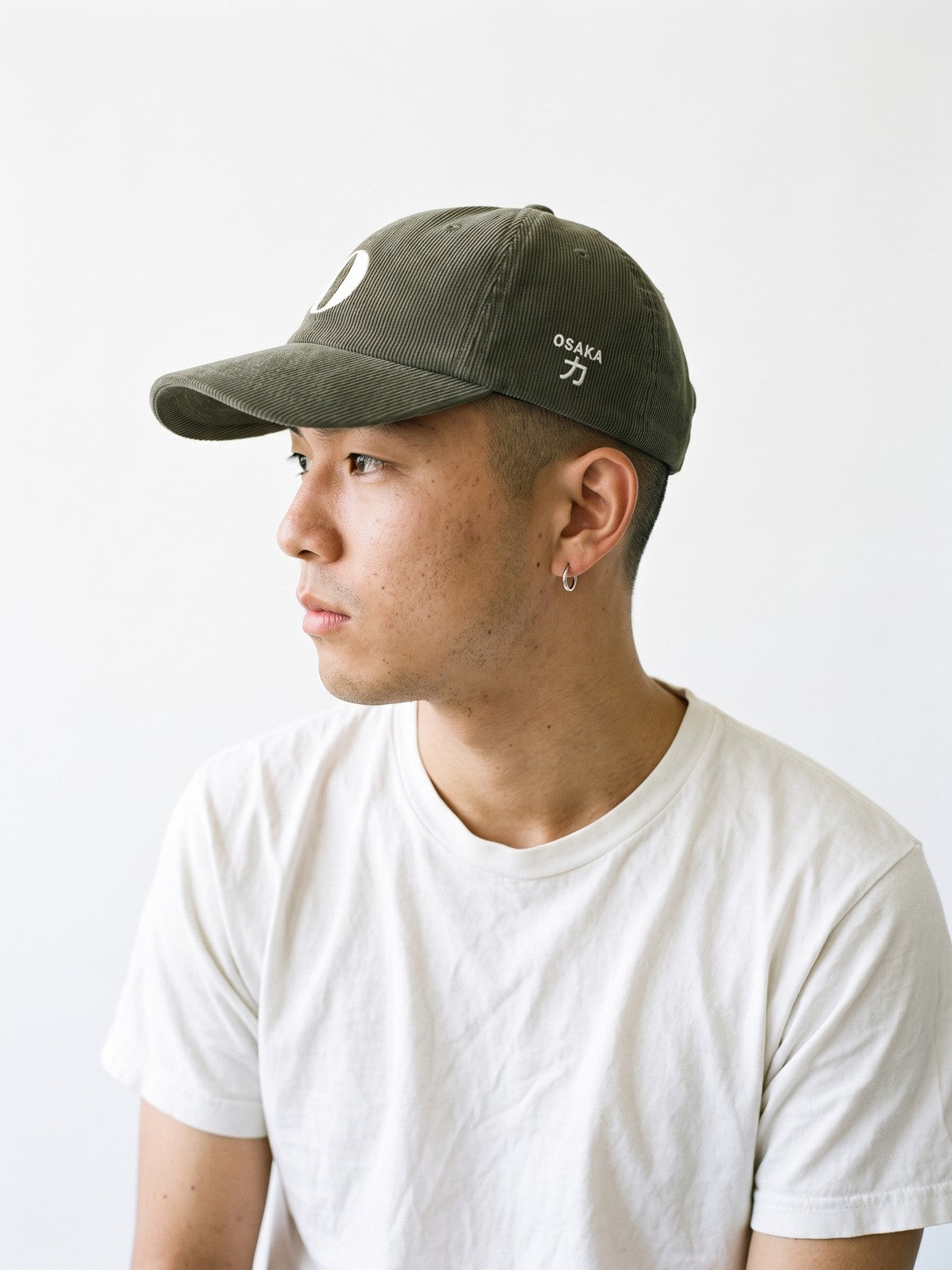 Side view of the 5C5V Osaka O Corduroy Japanese baseball cap in olive, OSAKA above 力 (strength) embroidered on the left side