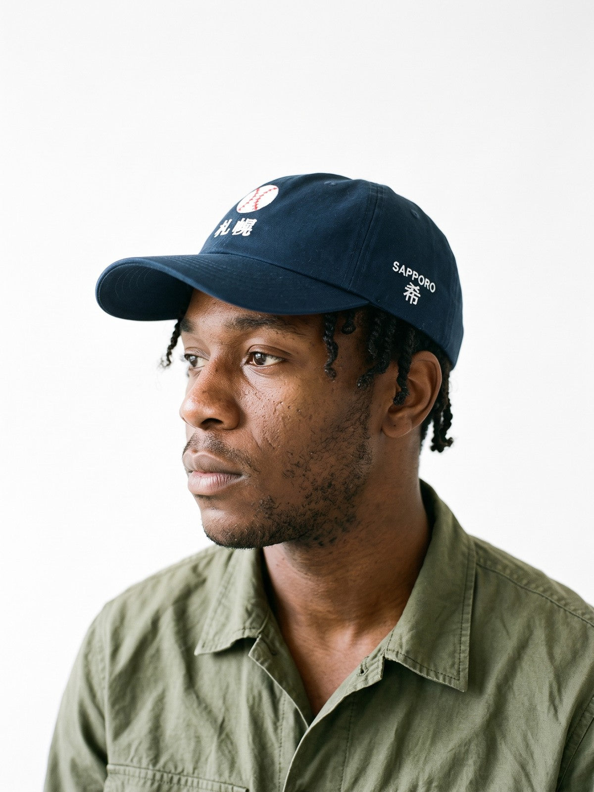 Side view of the 5C5V Sapporo Ball Japanese baseball cap in navy, SAPPORO above 希 (hope) embroidered on the left side