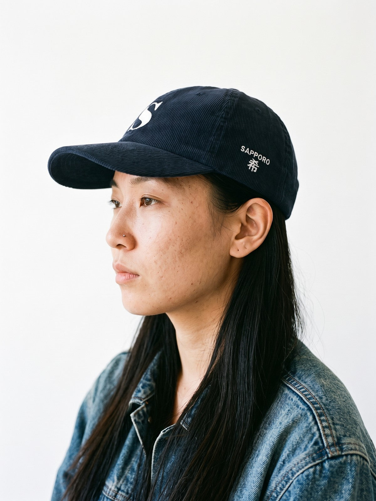 Side view of the 5C5V Sapporo S Corduroy Japanese baseball cap in navy, SAPPORO above 希 (hope) embroidered on the left side
