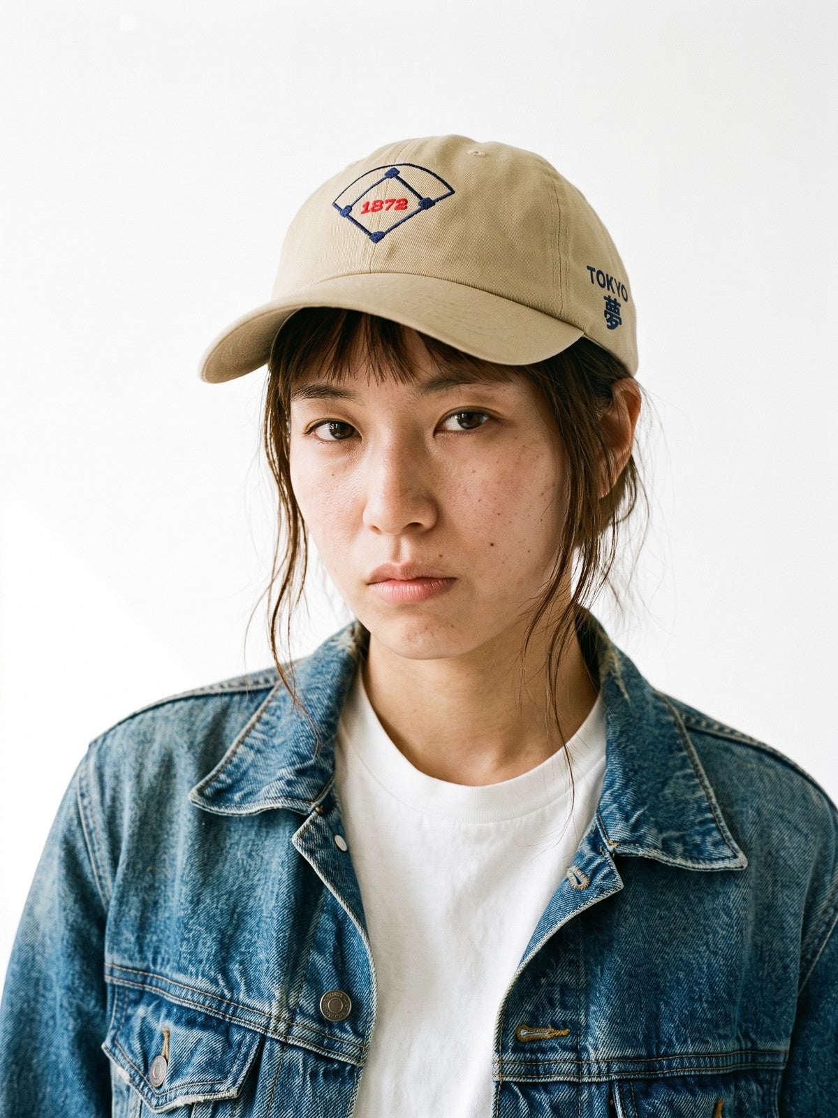 Model wearing the 5C5V Tokyo 1872 Japanese baseball cap in khaki, a baseball diamond with 1872 embroidered on the front, TOKYO and 夢 (dream) on the left side