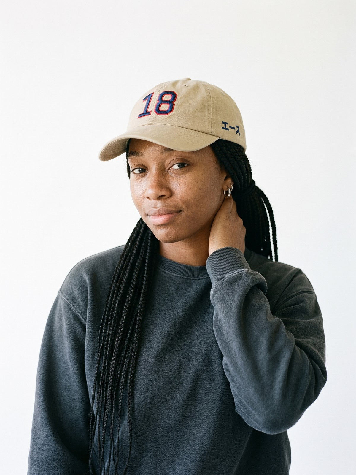 Model wearing the 5C5V Ace 18 Japanese baseball cap in khaki, 18 embroidered in navy with a red outline on the front, エース (ace) in navy on the left side