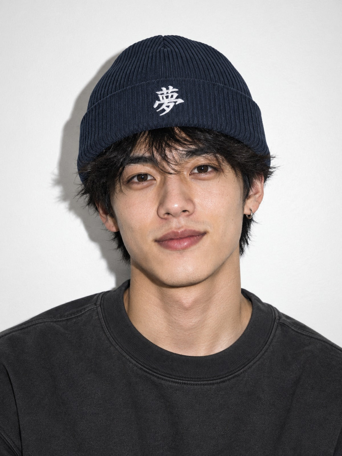 Model in a charcoal sweatshirt wearing the Navy 5C5V Tokyo Dream beanie with 夢 embroidered in white on the cuff, front view