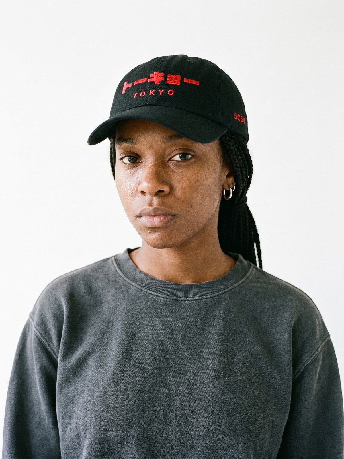 Model wearing the 5C5V Tokyo Katakana Japanese baseball cap in black, トーキョー over TOKYO embroidered in red on the front, 5C5V in red on the left side