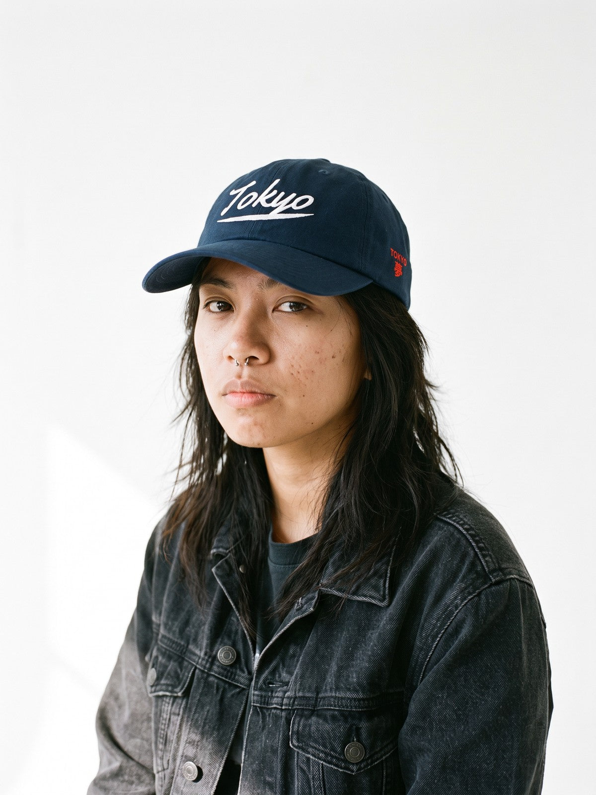 Model wearing the 5C5V Tokyo Script Japanese baseball cap in navy, Tokyo in ballclub script embroidered on the front, TOKYO and 夢 (dream) on the left side