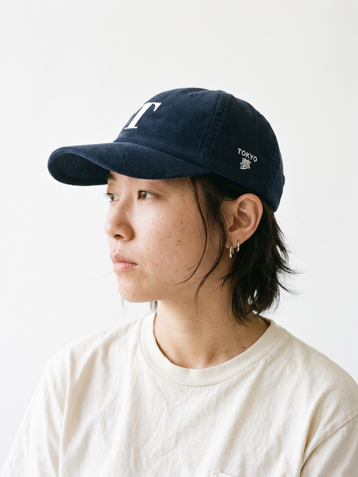 Side view of the 5C5V Tokyo T Corduroy Japanese baseball cap in navy, TOKYO above 夢 (dream) embroidered on the left side