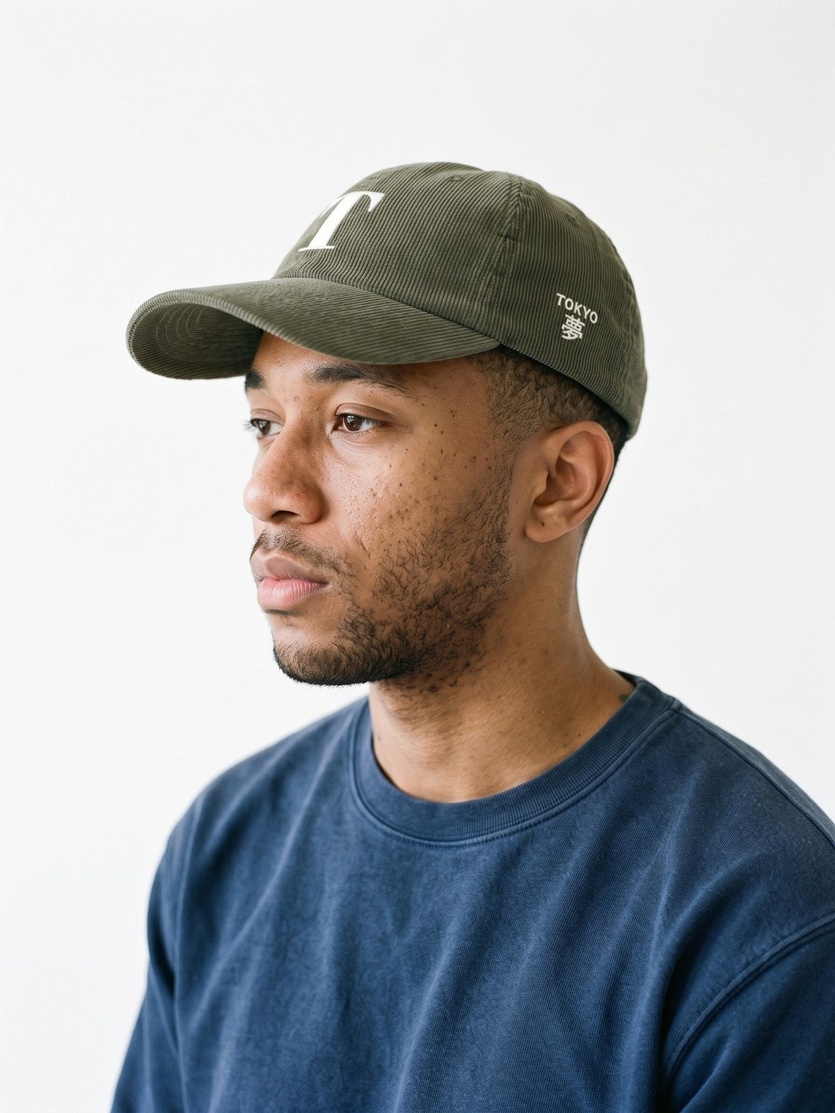 Side view of the 5C5V Tokyo T Corduroy Japanese baseball cap in olive, TOKYO above 夢 (dream) embroidered on the left side