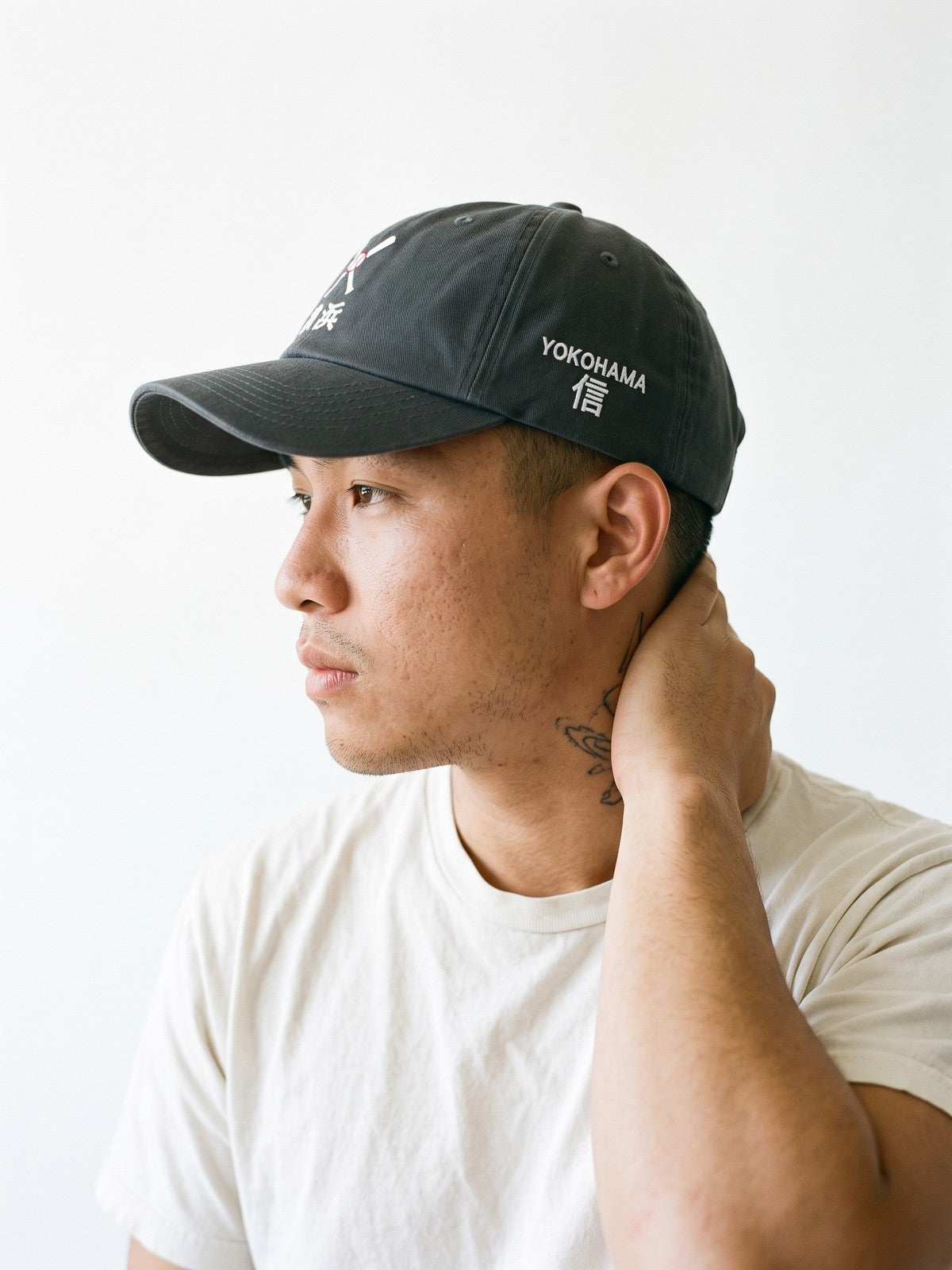 Side view of the 5C5V Yokohama Crossed Bats Japanese baseball cap in dark grey, YOKOHAMA above 信 (trust) embroidered on the left side