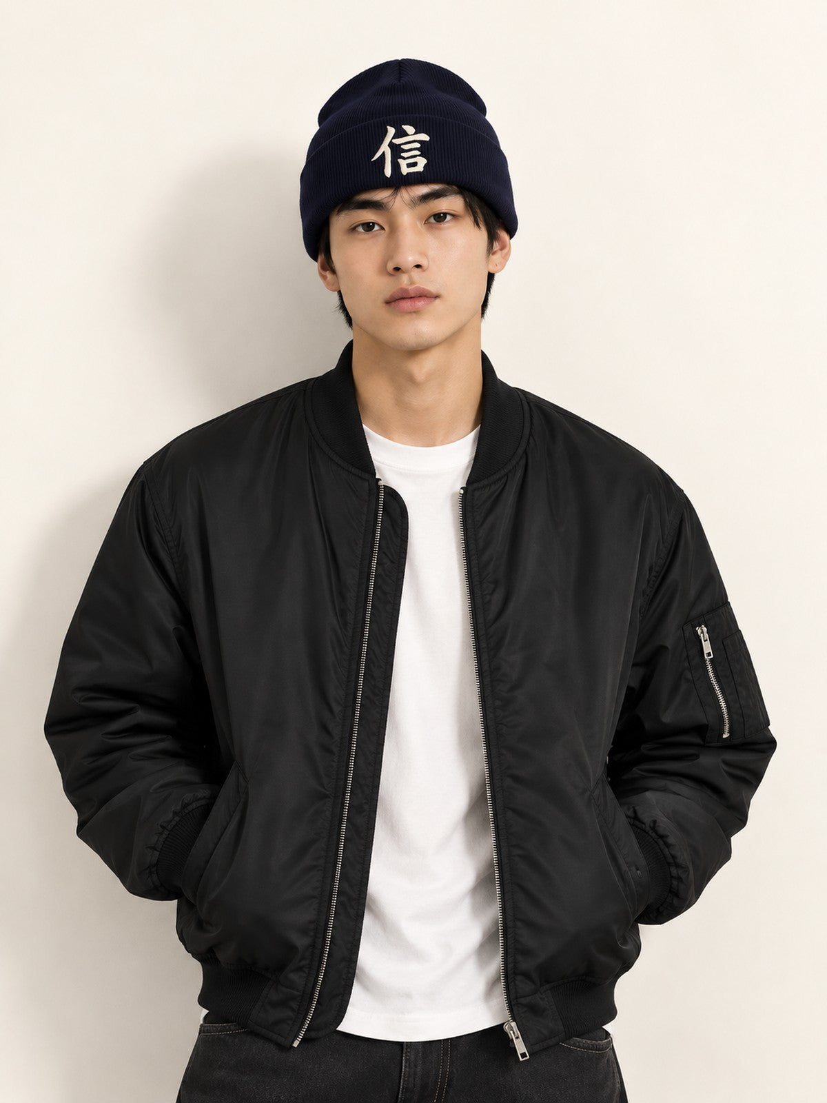Model in a black bomber jacket wearing the navy 5C5V Yokohama Trust 信 beanie, front view