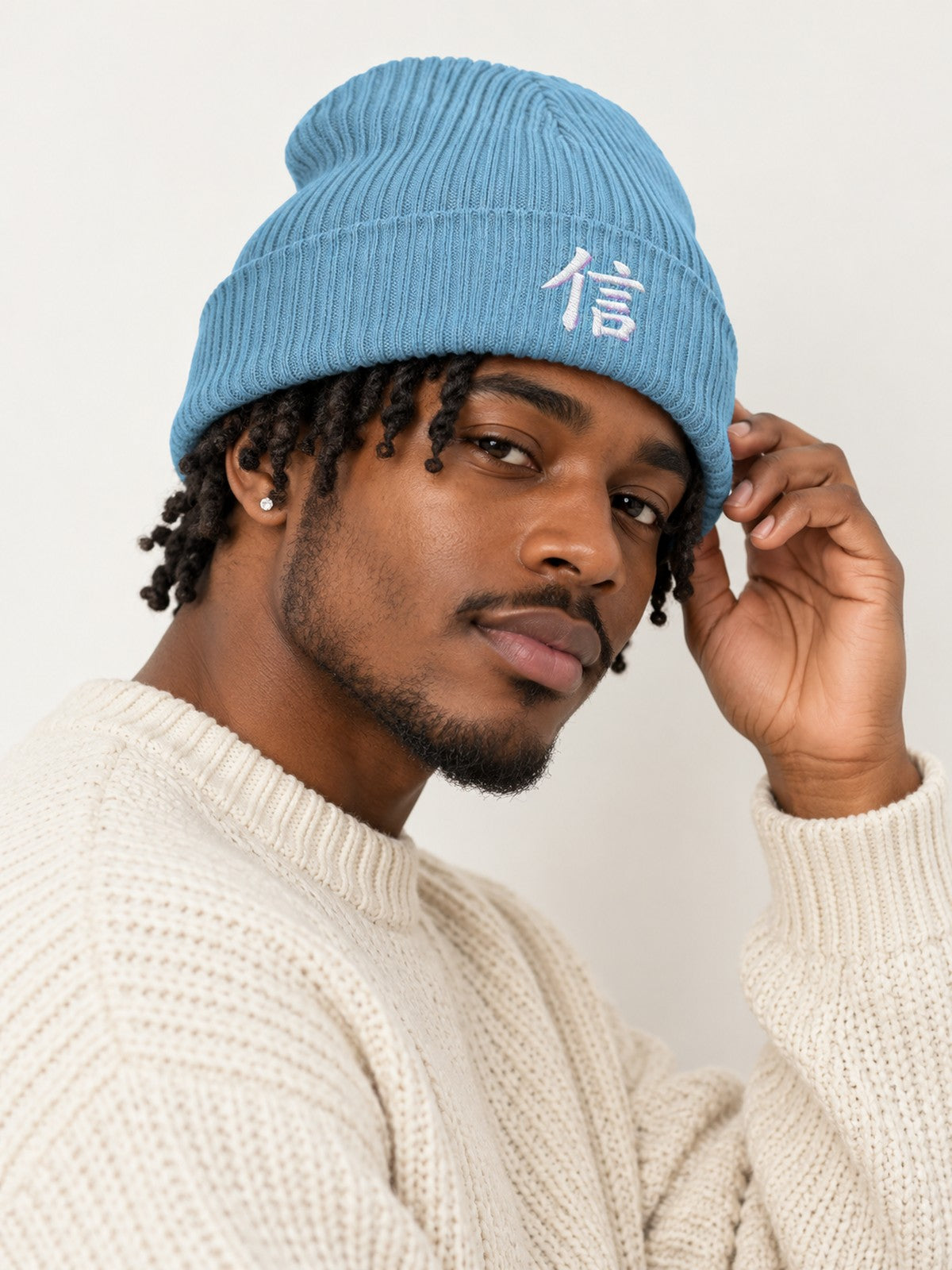 Model with short twists in a cream knit sweater wearing the Light Avio Blue 5C5V Yokohama Trust 信 ribbed beanie, side angle