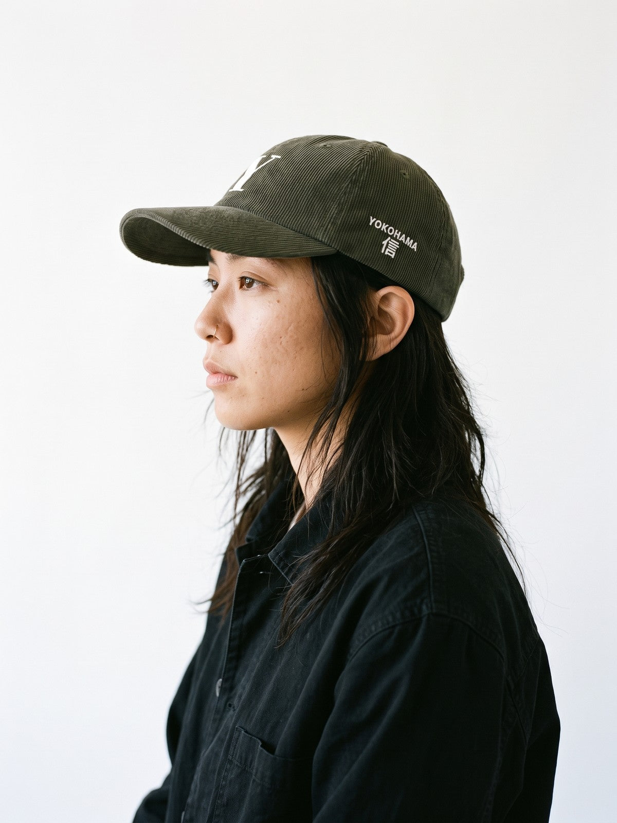 Side view of the 5C5V Yokohama Y Corduroy Japanese baseball cap in olive, YOKOHAMA above 信 (trust) embroidered on the left side