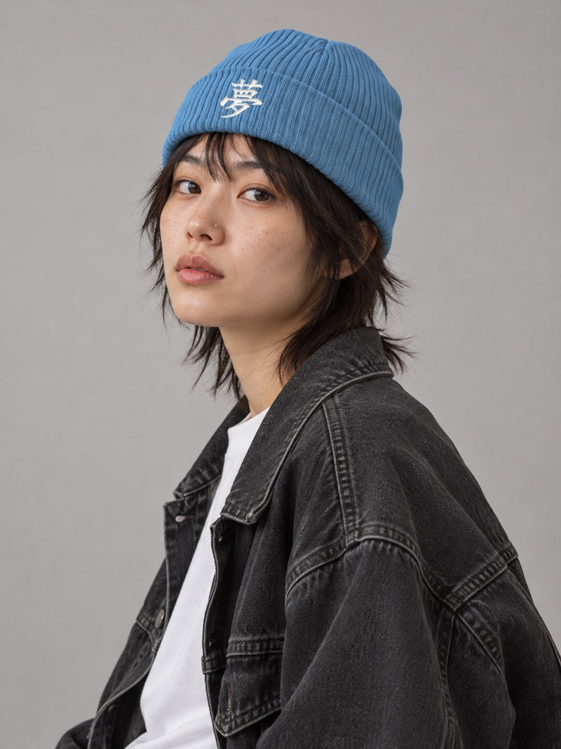 Model wearing the Light Avio Blue Tokyo Dream 夢 ribbed beanie in the studio, white satin-stitch 夢 embroidered on the cuff