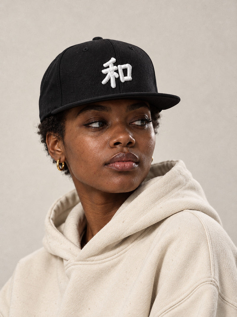 Model wearing the black Kyoto Harmony 和 Japanese Snapback, white 3D-puff 和 on the front