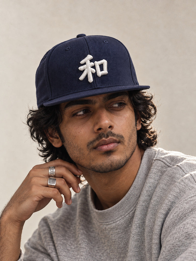 Model wearing the navy Kyoto Harmony 和 Japanese Snapback, white 3D-puff 和 on the front