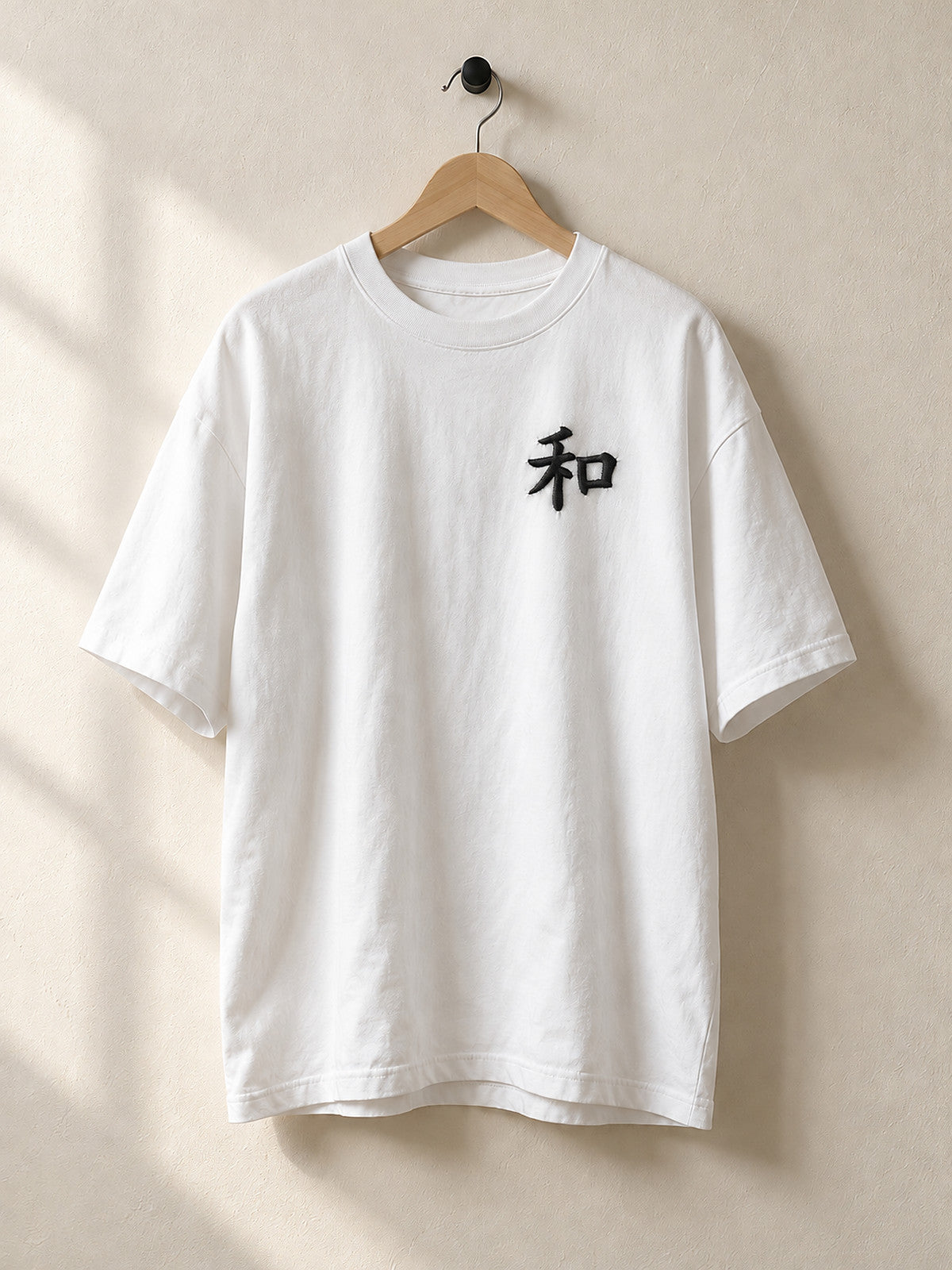 White Kyoto Harmony 和 premium oversized tee on a wooden hanger, front view
