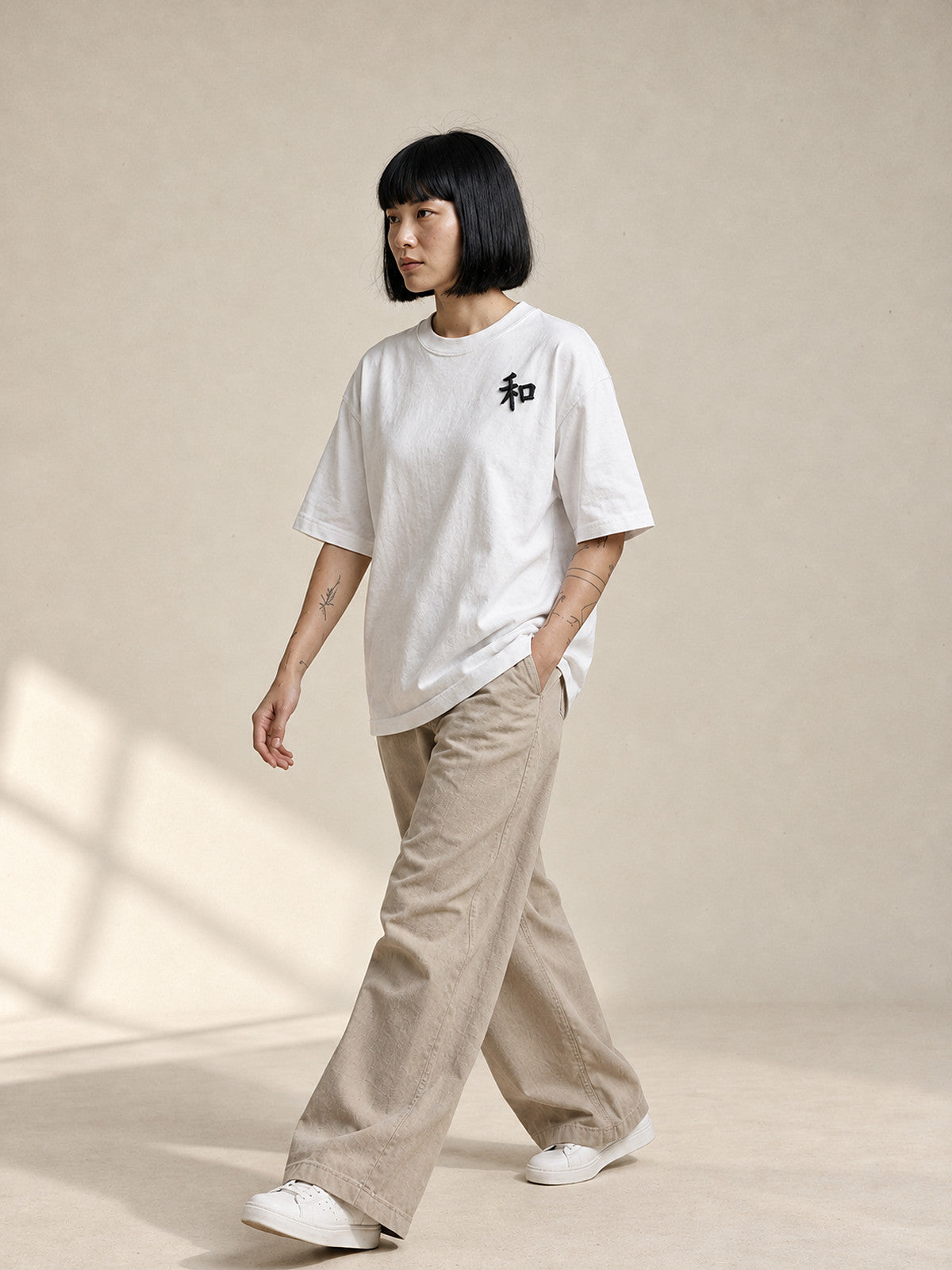 Model walking in the white Kyoto Harmony 和 premium oversized tee with stone wide-leg trousers, full length