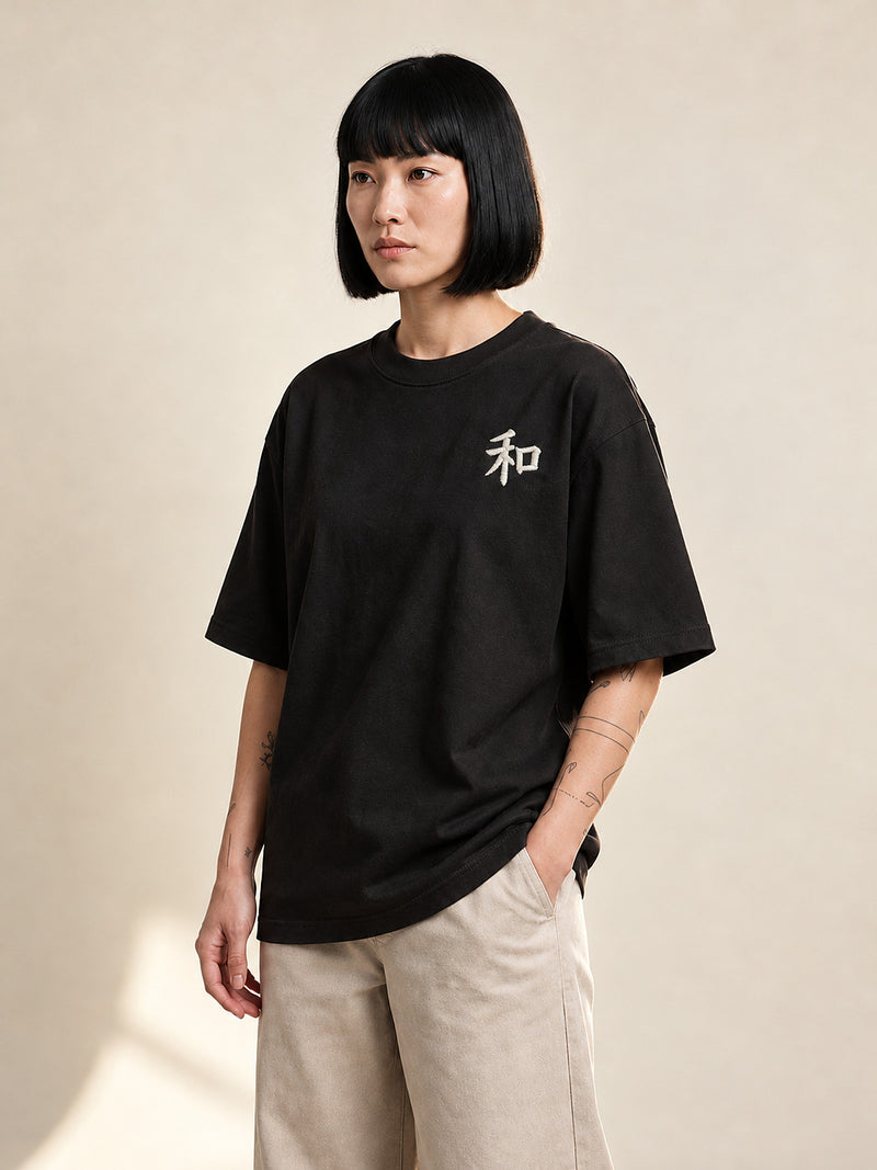 Model wearing the black Kyoto Harmony 和 premium oversized tee, front view with the white 和 kanji embroidered on the chest