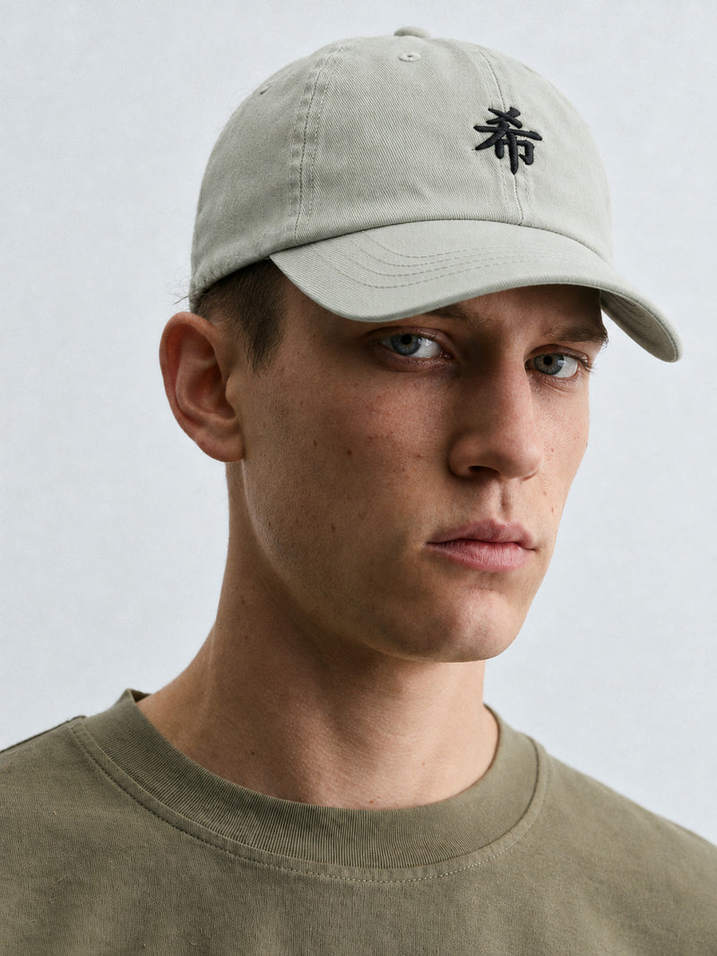 Close-up of a model in the pale mint Pale North 希 cap