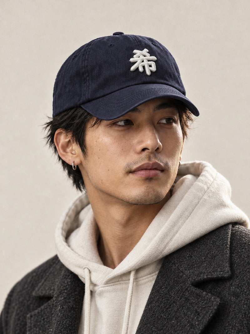 Model wearing the navy Sapporo Hope 希 Japanese Baseball Cap pulled low, white 3D-puff 希 on the front