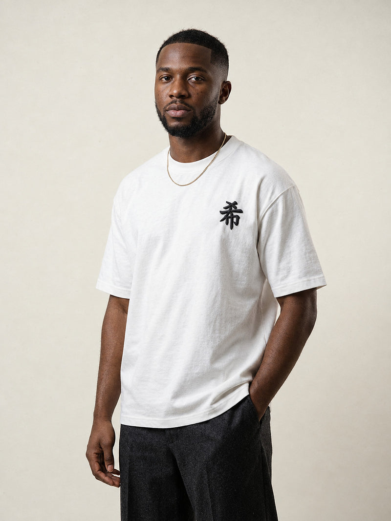 Model wearing the white Sapporo Hope 希 premium oversized tee, front view with the black 希 kanji embroidered on the chest