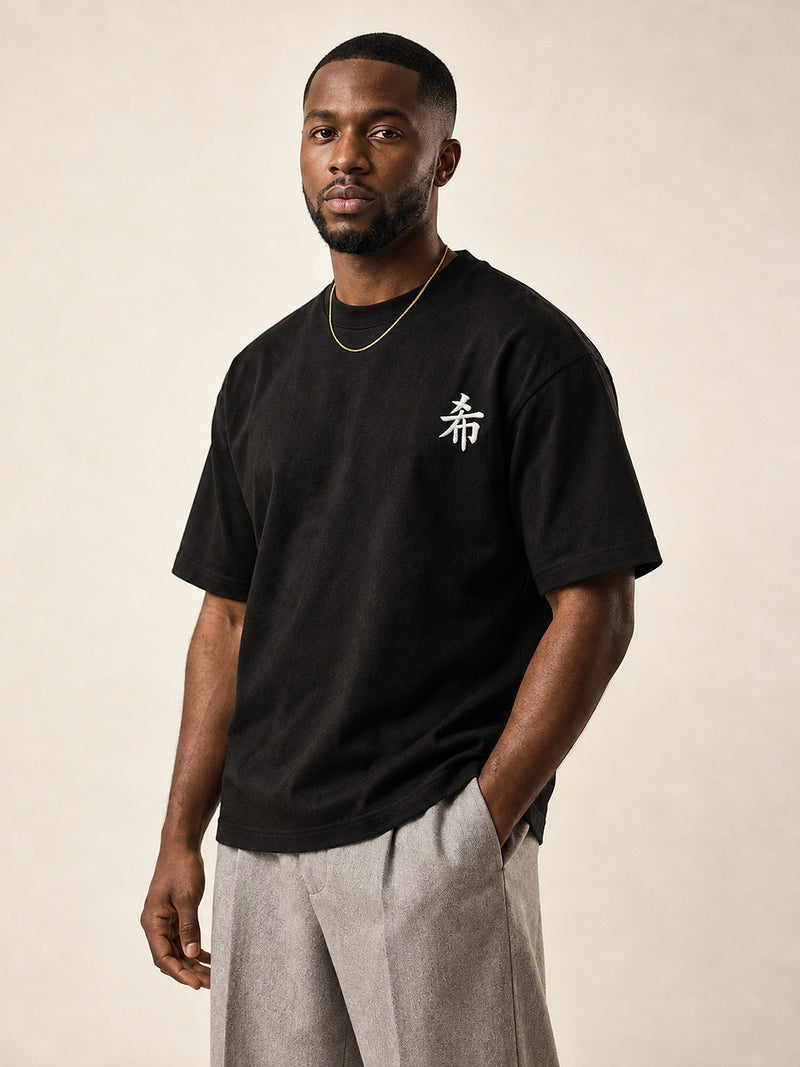 Model wearing the black Sapporo Hope 希 premium oversized tee, front view with the white 希 kanji embroidered on the chest