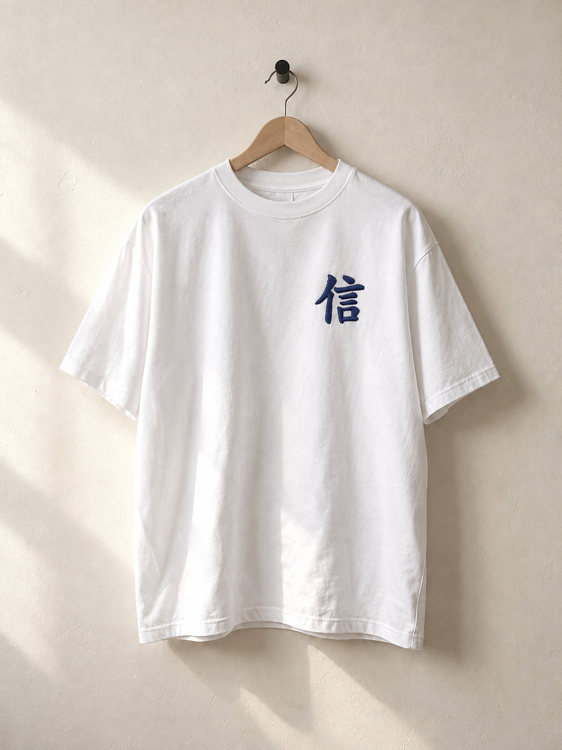 White Yokohama Trust 信 premium oversized tee on a wooden hanger, front view