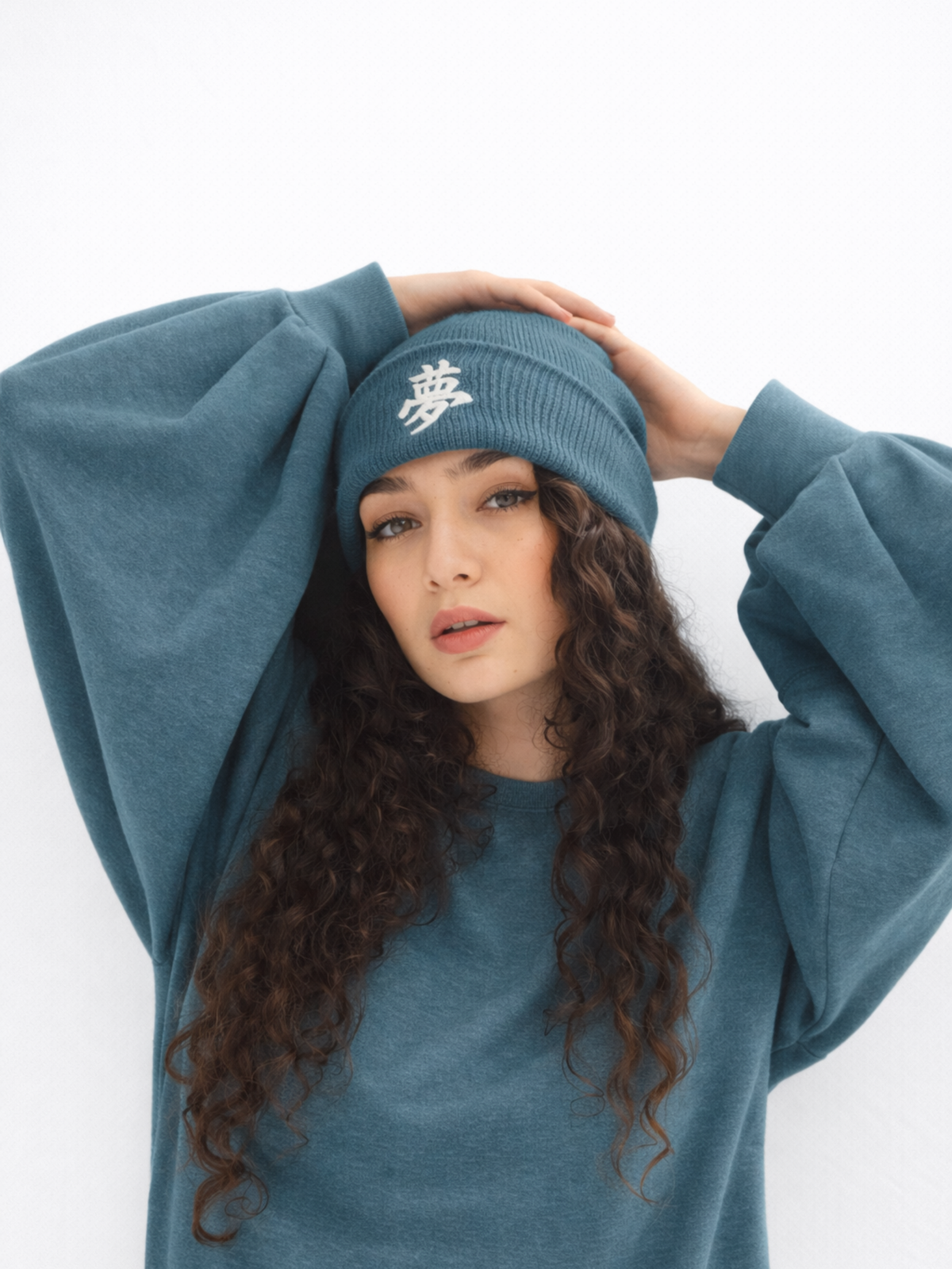 Petrol Blue Tokyo fisherman beanie with the kanji 夢 (dream) embroidered in white, worn by a model in a matching sweatshirt
