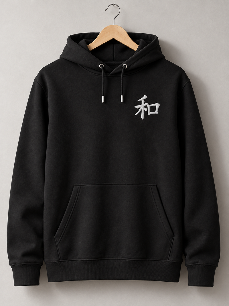 Black Kyoto Harmony 和 hoodie on a wooden hanger, front view with the small white embroidered 和 on the left chest