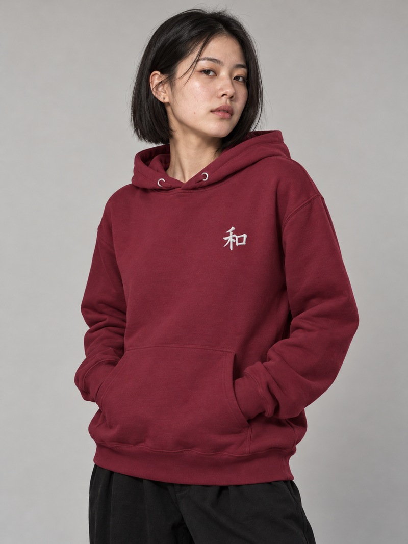 Model wearing the maroon Kyoto Harmony 和 hoodie in the studio, small white embroidered 和 on the left chest