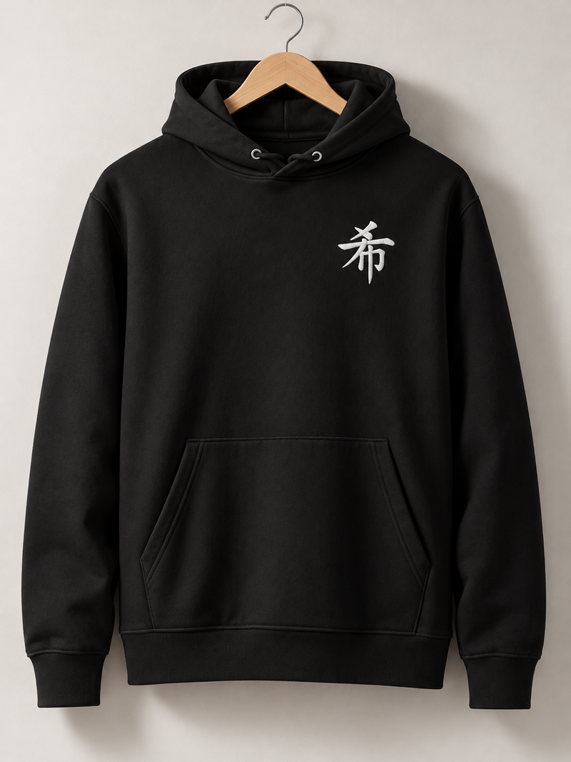 Black Sapporo Hope 希 hoodie on a wooden hanger, front view with the small white embroidered 希 on the left chest
