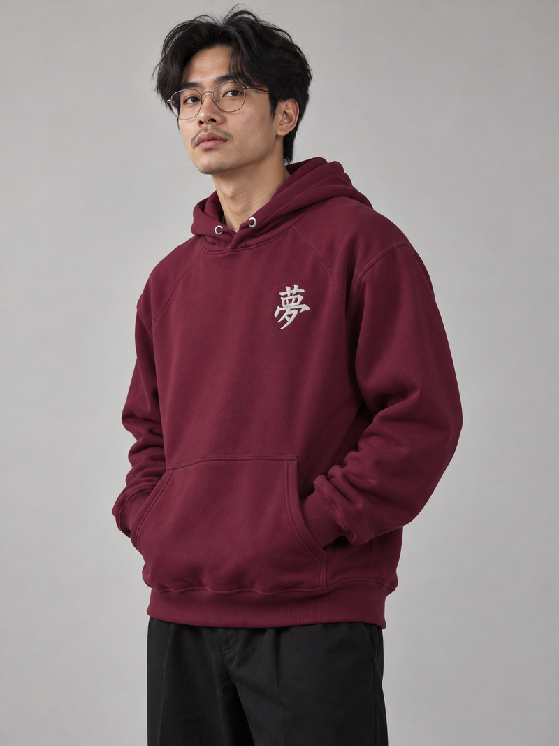 Model wearing the burgundy Tokyo Dream 夢 hoodie in the studio, small white embroidered 夢 on the left chest