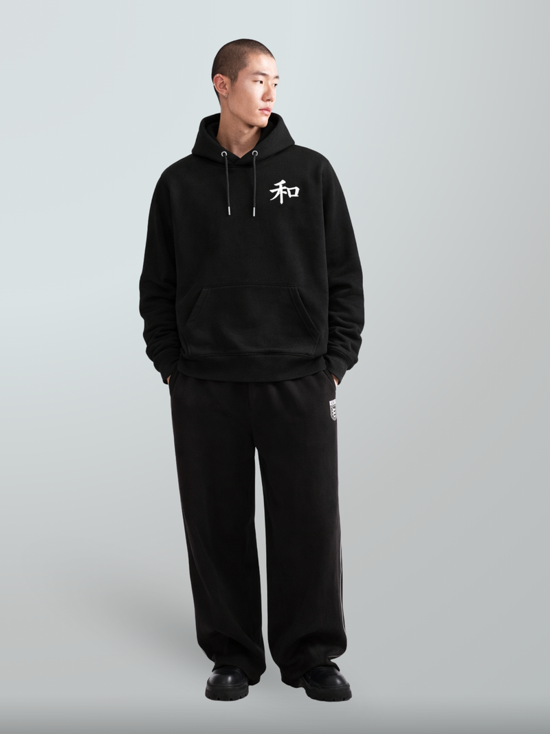 Full-length shot of a model in the black Kyoto Harmony 和 hoodie and black trousers