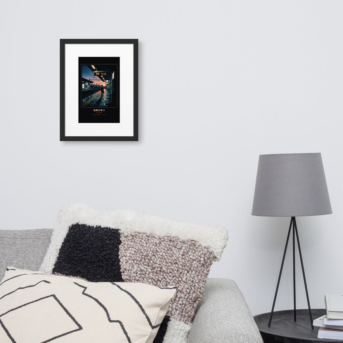 Black-framed Shihatsu 始発 (first train), 30×40 cm: a commuter awaiting Tokyo's first train at sunrise, on a wall over a sofa
