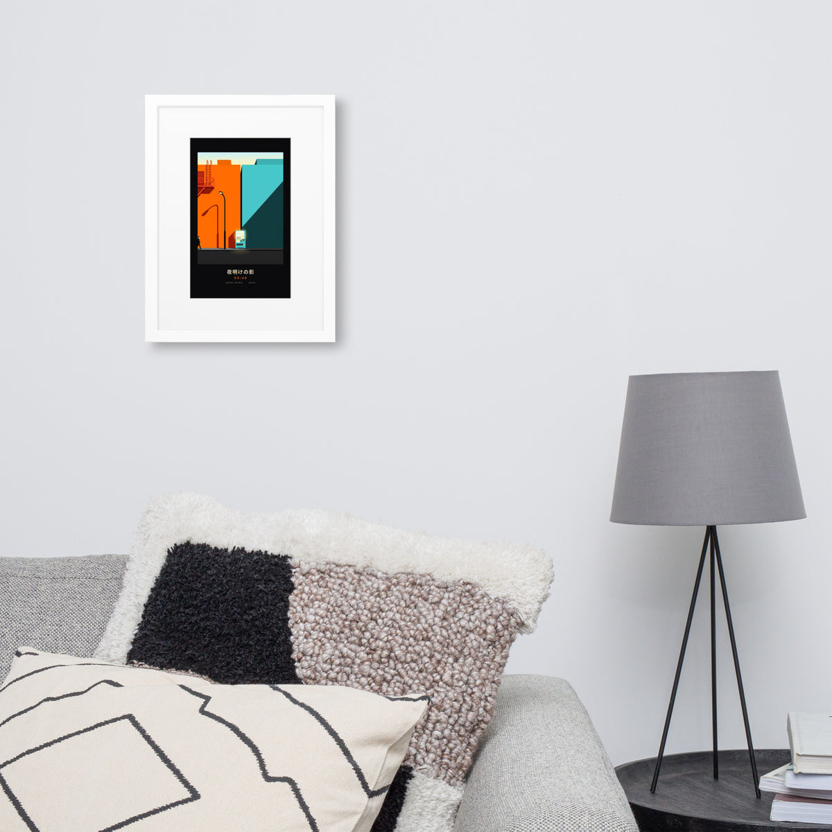 White-framed Kage 影 (shadow) print, 30×40 cm: an orange and teal Tokyo street at dawn, on a wall over a sofa