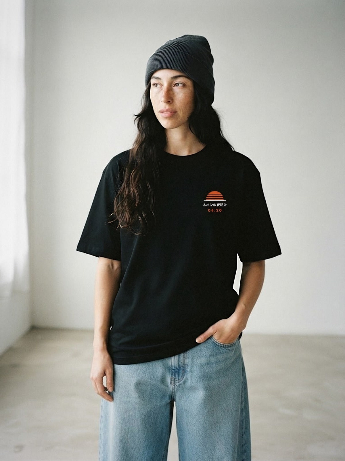 Model wearing the Neon Dawn Asa no Ippai 朝の一杯 black tee, front view with the embroidered 04:20 Neon Dawn sun on the chest