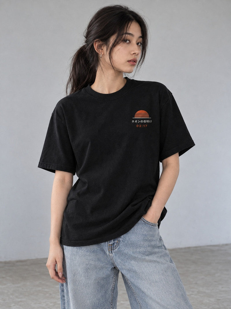 Model wearing the Neon Dawn Shin'ya Konbini black T-shirt from the front, with the small embroidered sunrise, ネオンの夜明け and orange 02:17 on the left chest