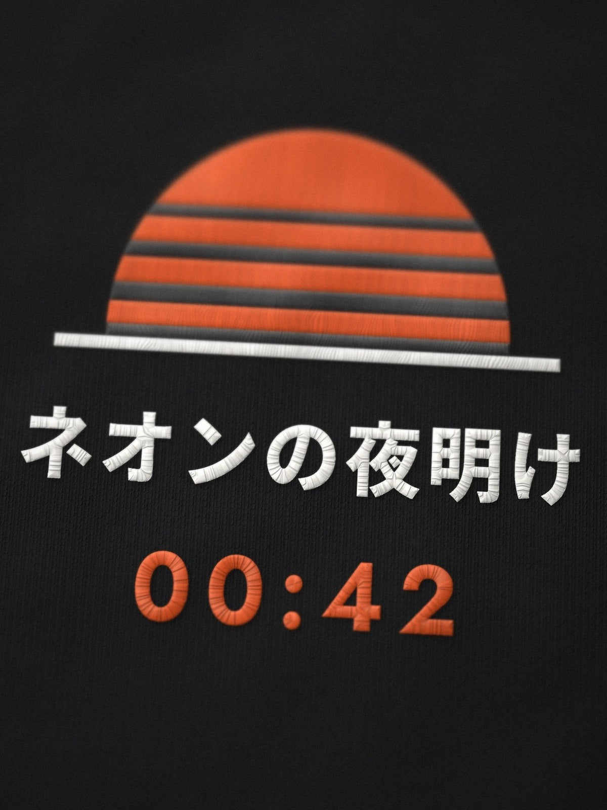 Close-up of the Neon Dawn chest embroidery: striped orange half-sun, ネオンの夜明け and 00:42 stitched on black cotton