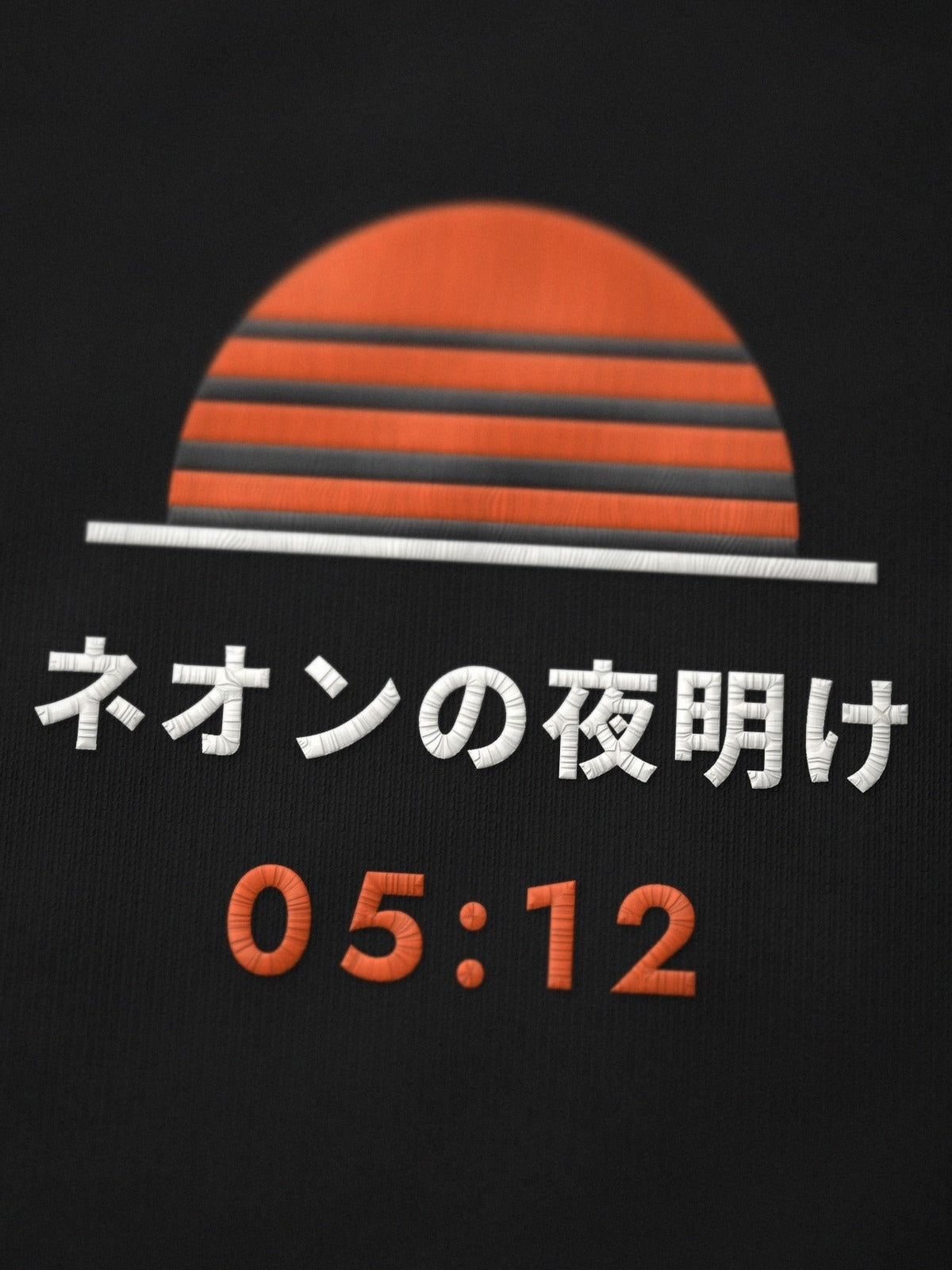 Close-up of the embroidered Neon Dawn sun on the Tokyo Bay 東京湾 black tee, ネオンの夜明け and 05:12 stitched in orange and white thread