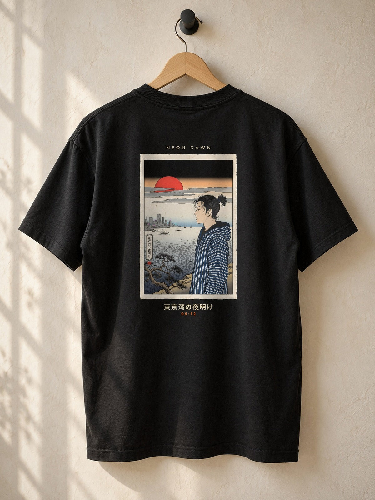 Neon Dawn Tokyo Bay 東京湾 heavyweight black tee on a wooden hanger against a plaster wall, showing the Edo woodblock-style Tokyo Bay dawn back print
