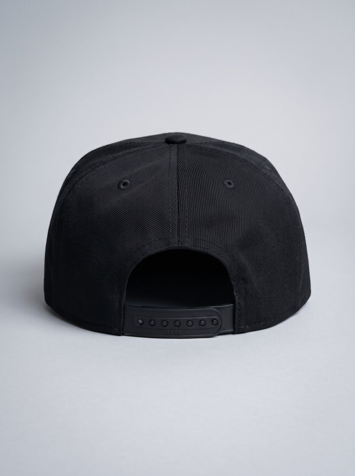 Back of the black snapback with adjustable snap closure