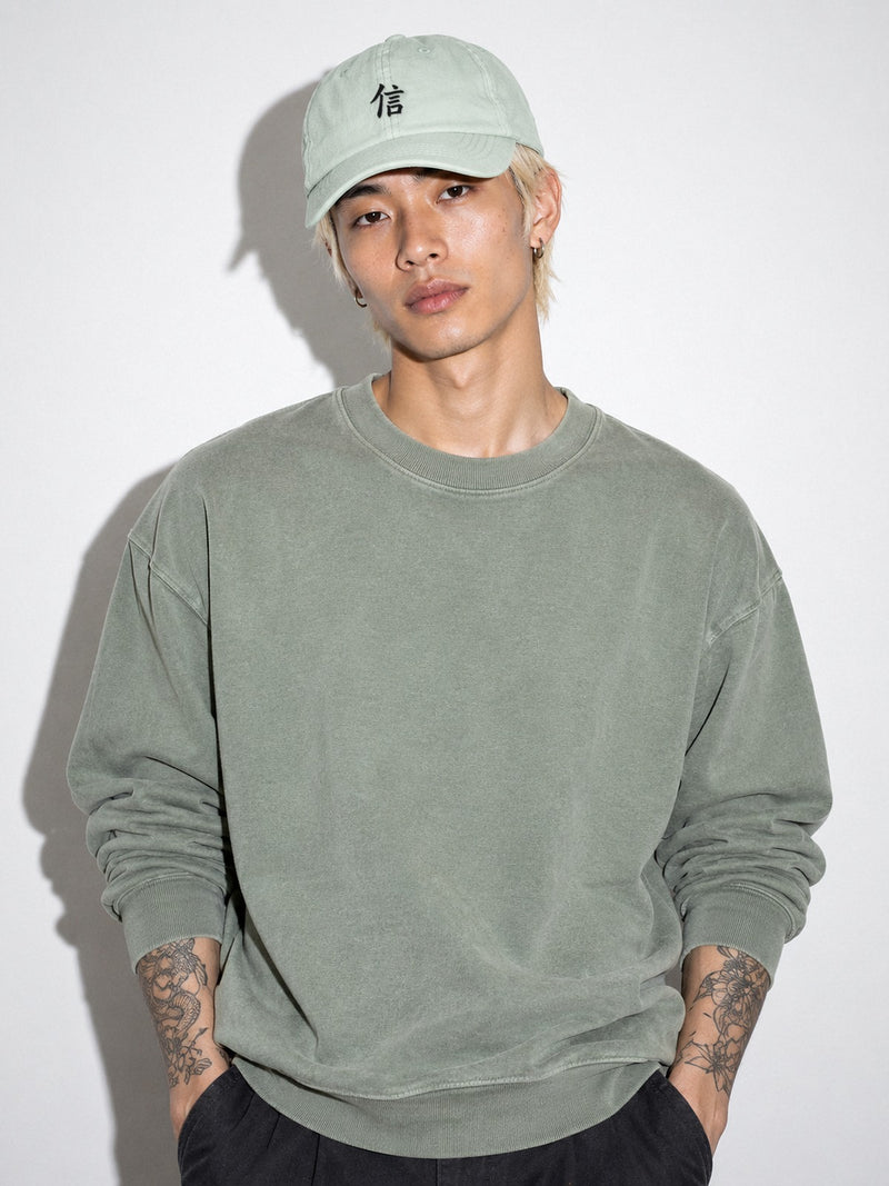 Model in a sage sweatshirt wearing the Pale North 信 pastel mint low pro cap with the black 信 (trust) kanji