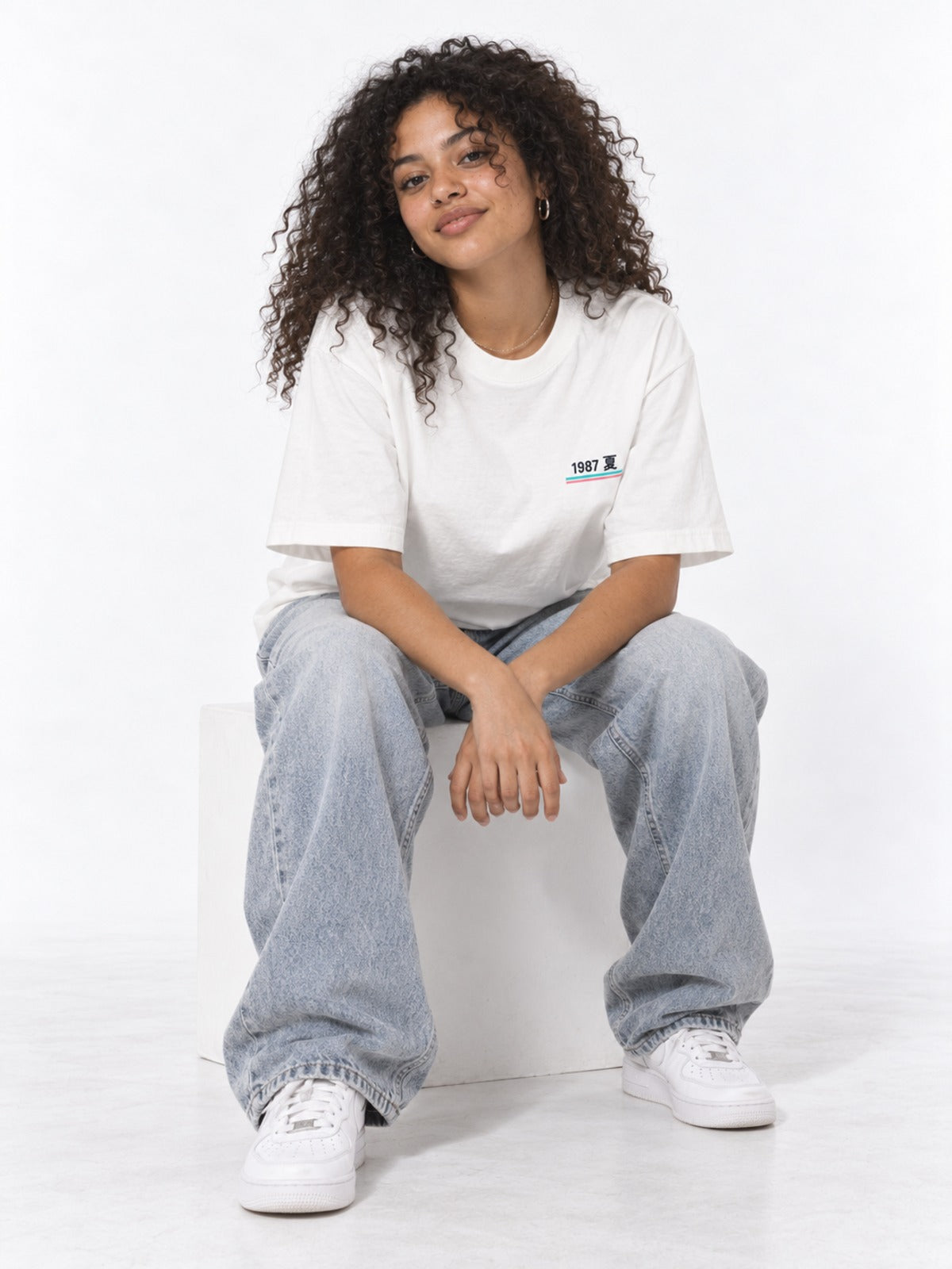 City Pop シティポップ 1987 Japanese Summer T-Shirt in white by 5C5V, on model, seated