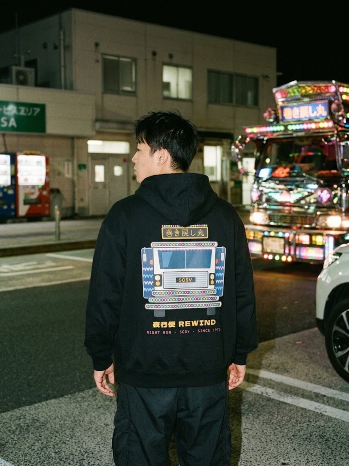 Dekotora デコトラ Japanese Black Hoodie by 5C5V at a late-night service area with a decorated truck